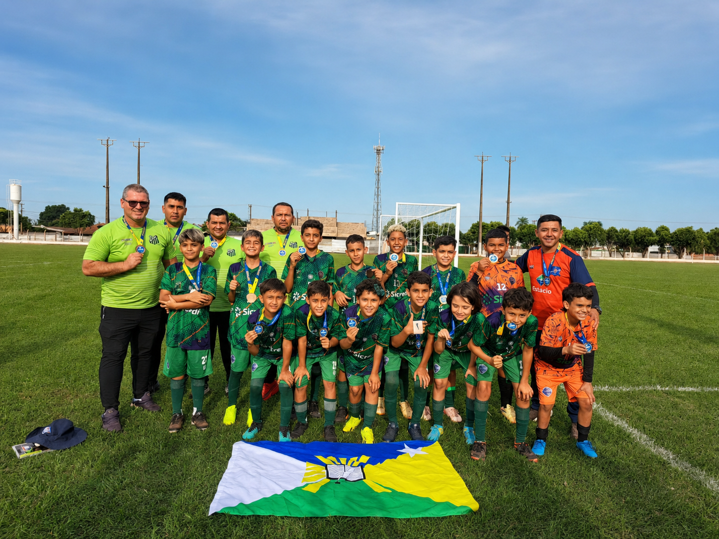 Atletas do MDV com medalhas ao lado da comissão técnica em campo