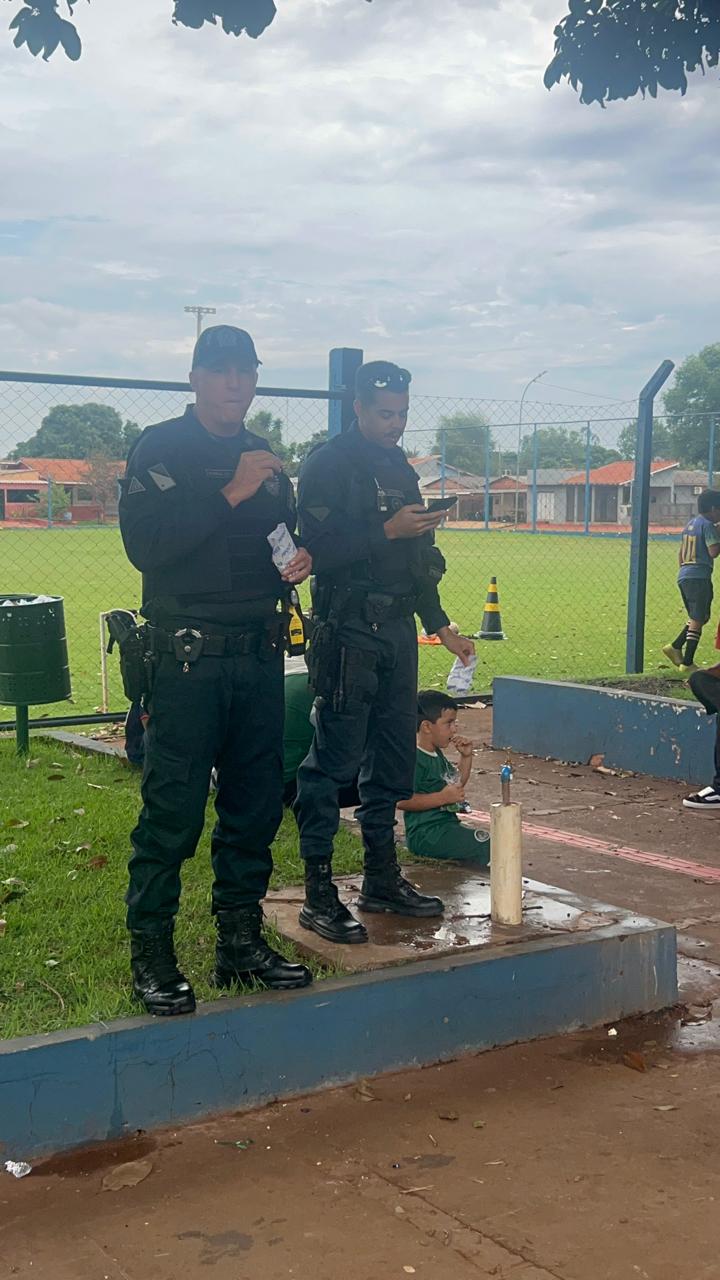 Policiais presentes na comemoração ao lado do campo de futebol