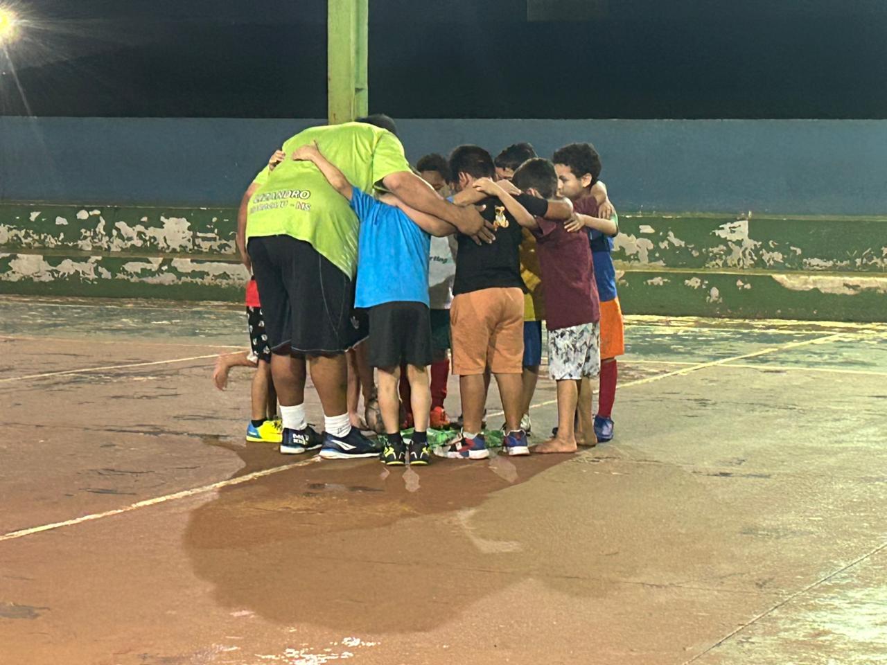 Atletas e professor reunidos em roda de união antes das atividades